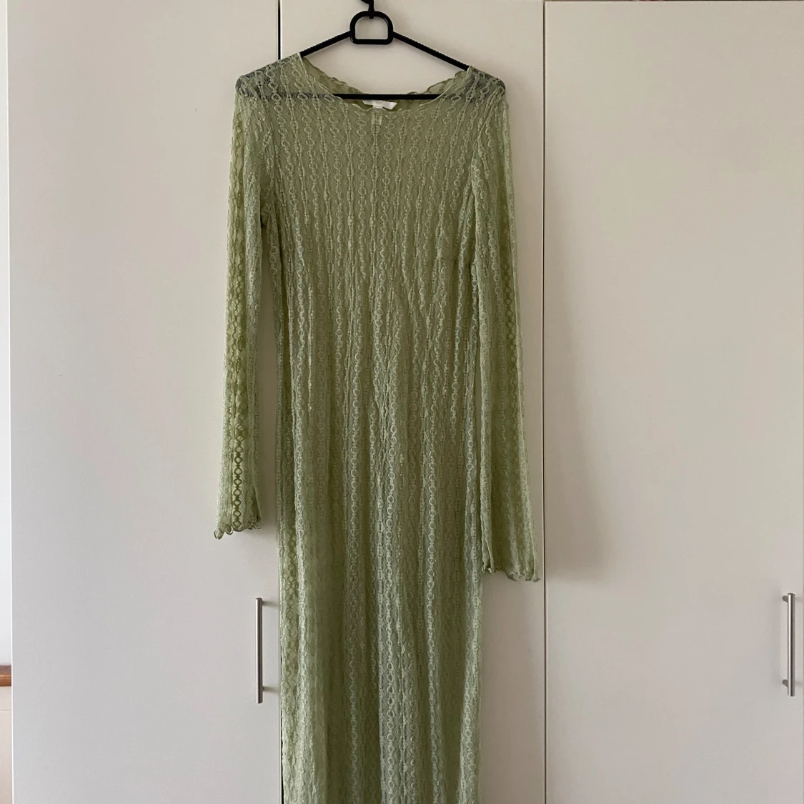 En ljusgrön klänning som är transparent med spets.
