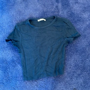 mörkblå magtröja  - den ser ut att sitta tajt men det könns inte som att det gör det. tröjan är gjort av ett mjukt material. och den är cropped 