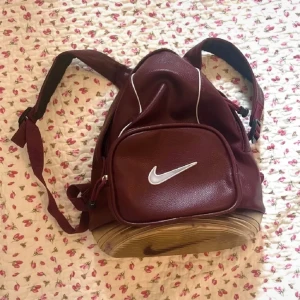 Nike 90s vintage leather bubble backpack  - vintage Nike läderryggsäck från 90-talet i vinröd färg. Den har mindre slitage, bubbelbotten har några fläckar inuti (från en penna). kanske kan gå bort med Vanish. mycket rare väska!!Mått ca 29x32