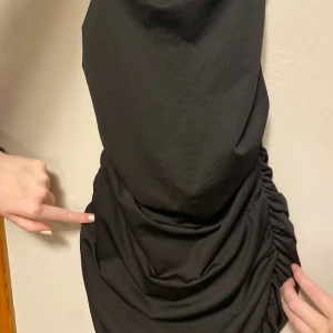 Svart festklänning - Festklänning som korsas i ryggen ganska öppen i ryggen, kort och snygg till fest, aldrig använd