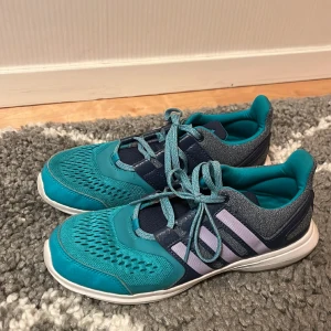 Inomhusskor adidas  - Ett par jättesköna inomhusskor i märket adidas i turkos/gråblå färg och lila ränder 🩵💜