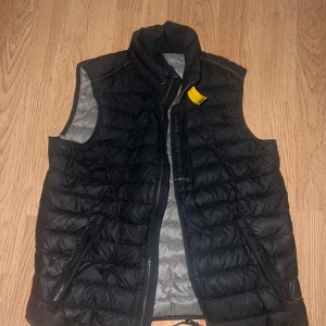 Parajumper väst  - En perfekt väst, dunväst som är varm samt väldigt fin. Används ej längre men är splitter ny. Västen är från Johnells, köpt för 3699kr. Kvitto från köpet ingår, samt prislappar och galjen som man får ingår. Parajumper väst, storlek M. Färg svart. 