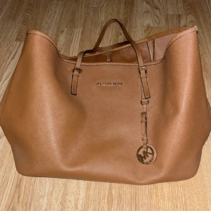 Michael Kors väska - Säljer min bruna Michael Kors väska i väldigt bra skick, nästan aldrig använd. Flera fack och väldigt rymlig.