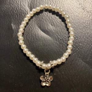 Ett sött men enkelt armband med vita pärlor och silver detaljer