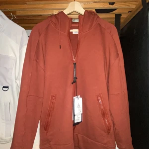 Cp company zip up  - Vin röd cp company tröja. Köpt på nk i somras, tagen från tröjan finns kvar. Storlek M , är 180 passar perfekt. Ny pris 3300. 