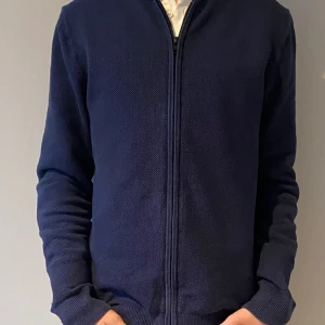Full zip Tommy hilfiger cardigan - Vi säljer en Tommy cardigan i topp skick som även har ett ny pris på 1800kr. Modellen på bilden är 170 men den är stor på han så den passar alla mellan 170-180cm. Priset går såklart att diskutera⭐️🧥 299kr kommer återgå till 349 efter mellandagsrean (30dec)
