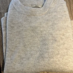 Beige stickad tröja från Ginatricot - Ylletröja i premium selection. En mjuk och bekväm ljusgrå stickad tröja från Ginatricot. Tröjan har en rund halsringning och långa ärmar.