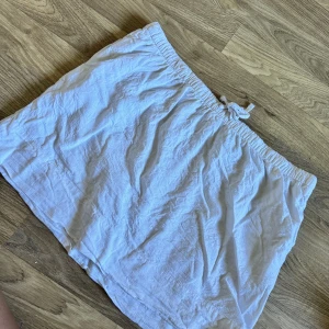 Vit kjol - En vit kjol med resår i midjan och knytband. Kjolen är av ett lätt och luftigt material, vilket gör den perfekt för varmare väder. 55% lin. Använd en gång. Normal i storlek.