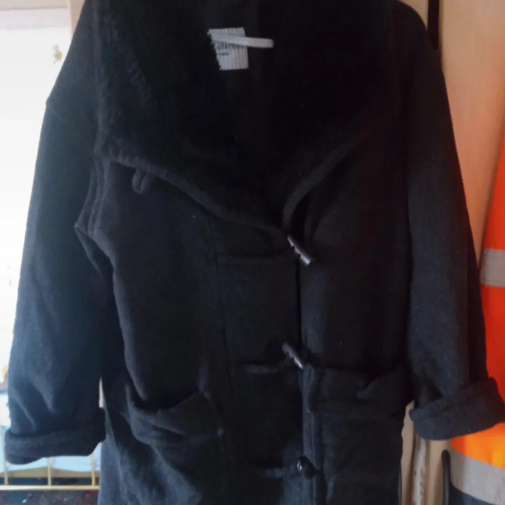 Svartgrå duffel ulljacka gråsvart stl M/L knäppes med knappar ,slitage kan förekomma men obetydligt se bilder.. Takit.