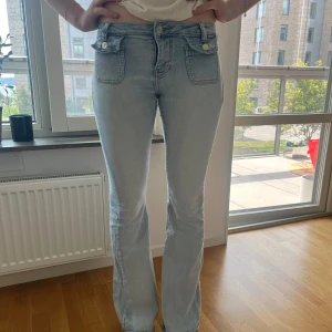 Lågmidjat jeans med fickor  - Jättefina jeans med coola fickor. Fin ljus färg och är lite stretchiga så passar 36/38 skulle jag säga. På sista bilden ser man att det finns slitningar vid jumskarna. Går att laga om man kan sy. 