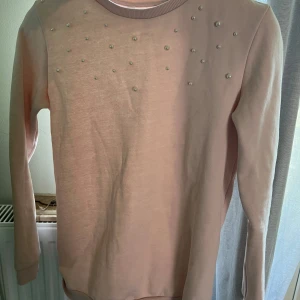  tjocktröja med pärlor - En jättesöt rosa tjocktröja med fina pärlor på! Säljer pga att den är för liten❤️ Den är i barn stl 158/164 men jag skulle säga att de är en XS
