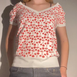 jättefin körsbärs topp - Fin tröja med körsbär på och fickor på framsidan, ser lite stor ut eftersom den är i storlek S och jag har storlek XS. säljer pga den inte används tyvärr, nyskick. 