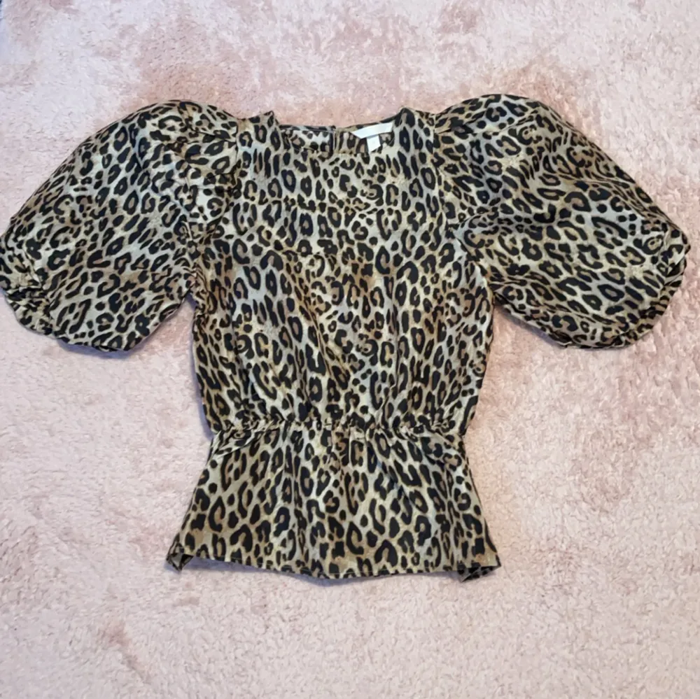 Elegant leopard blus med ”puffar” på armarna i storlek XS. Aldrig använd, inga defekter, skador eller hål. . Blusar.