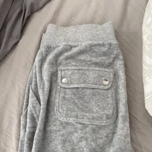 Juicy couture  - Grå juicy byxor i storlek xs men passar mig som är m!  Ett rivet hål på baksidan av byxbenet är ända tecknet på användning! Går lätt att sy ihop❤️