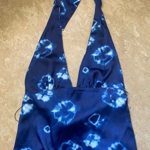 Blå och vit blommig top - En jätte fin blå och vit blommig top som går att knyta i halsen och är öppen i ryggen! Toppen är från Zara och är i storlek M!