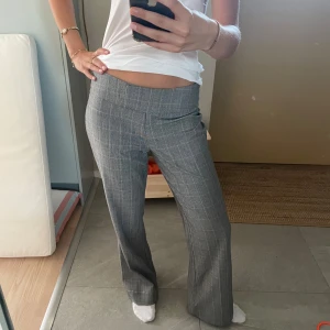 Gråa kostymbyxor - Rutiga gråa kostymbyxor, lågmidjade utsvängda! Perfekta till hösten. Storlek M. Köpta second hand