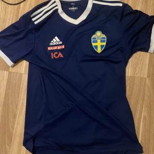 Sverige fotbolls tröja Herr medium - Sverige blå/gul/vit fotbolls tröja. Passform herr. Pris kan diskuteras