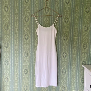 Vit sommarklänning  - Vit sommarklänning i medel längd, står ej storlek men uppskattar XS-S då den är stretchig. Två lager tyg så ej genomskinlig 