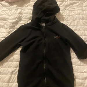Svart jacka från McKenzie - En svart zip up hoodie från McKenzie med dragkedja och huva. Jackan har långärmade ärmar och är tillverkad i ett mjukt material. Är i okej skick 