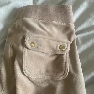 Juicy Couture byxor - Säljer ett par beigerosa juicy byxor med guld detaljer.  Dom är super fina men säljer då det inte är min stil längre. Dom är i hyfsat bra skick. Men använda, säljer därför billigt. Går att föreslå lägre pris❤️ Köpare betalar för frakten 