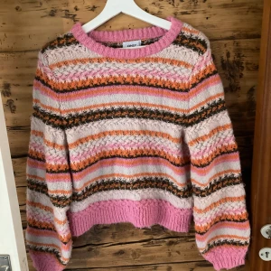 Stickad tröja - Stickad tröja med härliga färger! Lite nopprig. Har lite ballong-ärm och ganska kort och bred för att vara M men snygg på. 