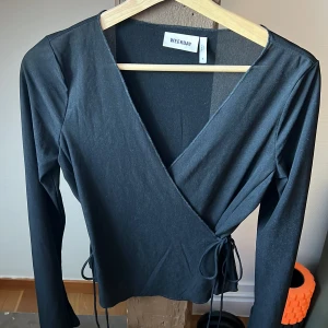 Omlottblus weekday - Svart omlottblus/topp som knyts i sidorna. Superfin!