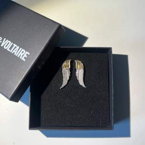 Zadig & Voltaire ”embellished wing earrings” i nyskick, säljer då dem inte kommer till någon användning. Inga defekter och lådan medför. Nypris för dem är 1095 kr på Farfetch. Köp gärna via ”köp nu” funktionen 😊