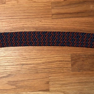Flätat bälte  - Säljer det här nya och oanvända flätade bältet. Hela bältet bortsett från metallbiten är ca 98 cm långt, men kan stretchas ut till en större storlek. Pris: 59 kr