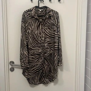 Lång blus - Mönstrad blus, brun/beige. Finns även band till midjan i samma mönster.