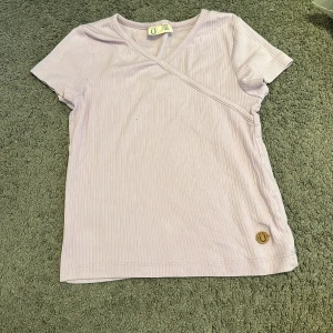 Lila T-Shirt - Lila/pastel lila T-shirt från Lindex i storlek 134/140,Väldigt nytt sckick säljer pga inte min stil!❤️