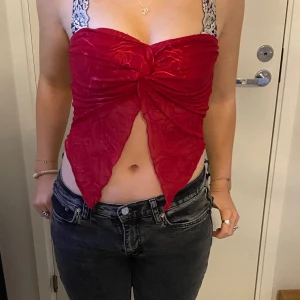 Röd topp  - En röd fin festlig top som säljs ENDAST för att jag inte tycker jag passar i den. Aldrig använd, bara provad.   Det står storlek L då den går att töja ut en del, men min kusin som modeller på bilden har storlek S, så den passar som det med. 