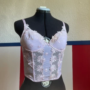 Blommig korsett topp - Super gullig blommig korsett topp. Har lite missfärgning på en kupan. Går nog att tvätta ut rätt lätt.