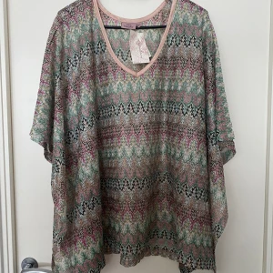 Mönstrad poncho - En mönstrad poncho från Kappahl i storlek M/L. Helt ny 