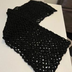 Svart stickad halsduk - Glesstickad. Ingen ull. 2 m 70 cm lång. 30 cm bred.