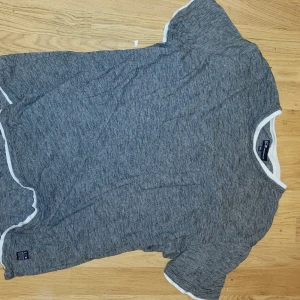 En grå tröja  - En grå tröja med vita slut