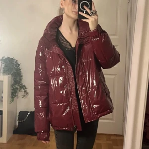 Jacka  - Säljer åter igen denna röda glansiga pufferjacka då det var så hög efterfrågan❣️Kan gå ner i pris vid snabb affär. Avtagbar luva medföljer men är inte med på bilden! Storlek 38, i gott skick från wohio. Jackan finns inte att köpa längre ❤️Varm och praktisk då den har både dragkedja å knappar! Går bra att klicka på köp nu 💓