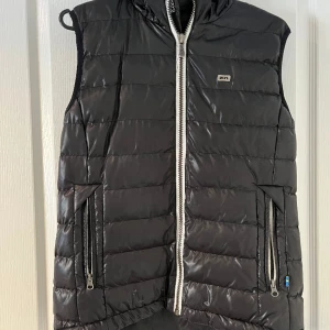 Glansig väst  - En glansig väst med vit dragkedja 