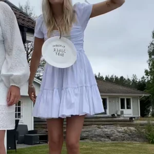 Klänning - Säljer min studentklänning. Den är i fint skick. Endast använd på studenten. Funkar bra som vanlig sommarklänning. Öppen i ryggen med band som knyts.