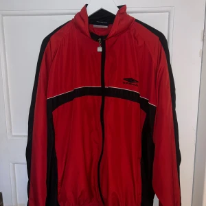 Vintage Umbro Jacka - Säljer denna thriftad vintage Umbro regnjacka. Den är i utmärkt skick med inte några synliga tecken på slitage.
