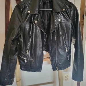 Skinnjacka - Skinnjacka (fakeskinn) Använd endast en gång, men storleken var för liten för mig så därav säljer jag jackan.   Något mindre i storlek, skulle säga mer 38 än 40.