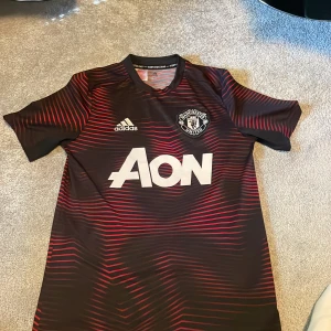 Adidas Manchester United tränings t shirt - Säljer en Manchester United tränings tröja pga förliten. Köpt på United shopen är använd ett par gånger. Det är storlek L i barn. Passar 13 till 14 åringar 