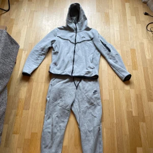 Niketech träningsoverall  - En grå Niketech som är knappast använd och har inga fläckar. Den är storlek M men kan passa L Om man bara vill köpa en av föremålen skriv privat