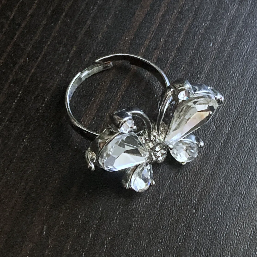 Silverfärgad justerbar ring med strass. Bredd: 2,7 cm.. Accessoarer.
