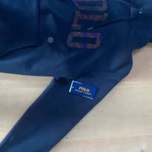 Polo Ralph Lauren Hoodie - Detta är en Hoodie från Polo Ralph Lauren. Färgen är i Navy och är i storlek M. Som man kan se i bilden har Hoodie aldrig används eftersom att lappen är kvar. Den är i väldigt bra skick.