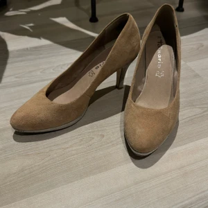 Mockapumps - Ett par beige mockapumps från Tamaris i storlek 38. Använda ett fåtal tillfällen.