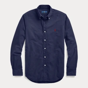 Custom Fit Marinblå Ralph Lauren skjorta i oxford material  - Hej! Säljer nu min sparsamt använda marinblåa Ralph Lauren skjorta eftersom den inte kommer till användning. Skick 9/10 inga defekter! Nypris: 1695kr mitt pris: 499kr. Fråga gärna om fler bilder eller om du har några andra frågor! Jag är 190cm. 