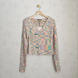 Supersöt färgad stickad kofta - 🧚🏻‍♀️FÖRST TILL KVARN!🧚🏻‍♀️ Super gullig stickad kofta i färgat garn med små rosa hängande körsbär på. Från Asos, missguided. Helt slutsåld på hemsidan, ville byta stirlek men då var den redan slut på nätet. Nyskick, aldrig använd med lappar kvar!🍡❤️