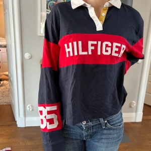 Tommy Hilfiger långarmad kragtröja - Tommy Hilfiger långarmad croppad kragtröja. Storlek XXL men sitter oversize på mig som medium. Den är i mycket bra skick. Pris kan diskuteras! Köparen står för frakt men vid köp av två eller fler plagg står jag för det. Kan även mötas upp!