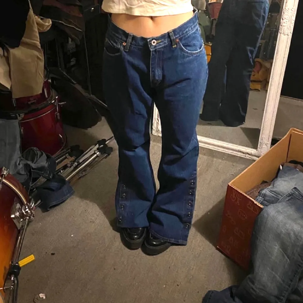 FÖR snygga vintage Blåa bootcut jeans med knappar på sidorna 🫶 I Jättebra skick och är endast testade av mig. De är i storlek M/38 och modellen på bilden har storlek XS-S och är 167 cm lång! Hör av dig för fler bilder ⭐️⭐️⭐️. Jeans & Byxor.