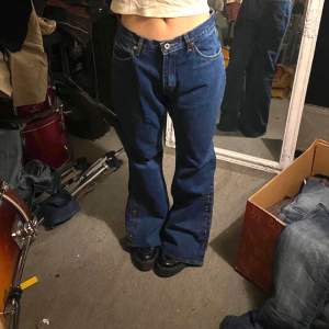 FÖR snygga vintage Blåa bootcut jeans med knappar på sidorna 🫶 I Jättebra skick och är endast testade av mig. De är i storlek M/38 och modellen på bilden har storlek XS-S och är 167 cm lång! Hör av dig för fler bilder ⭐️⭐️⭐️